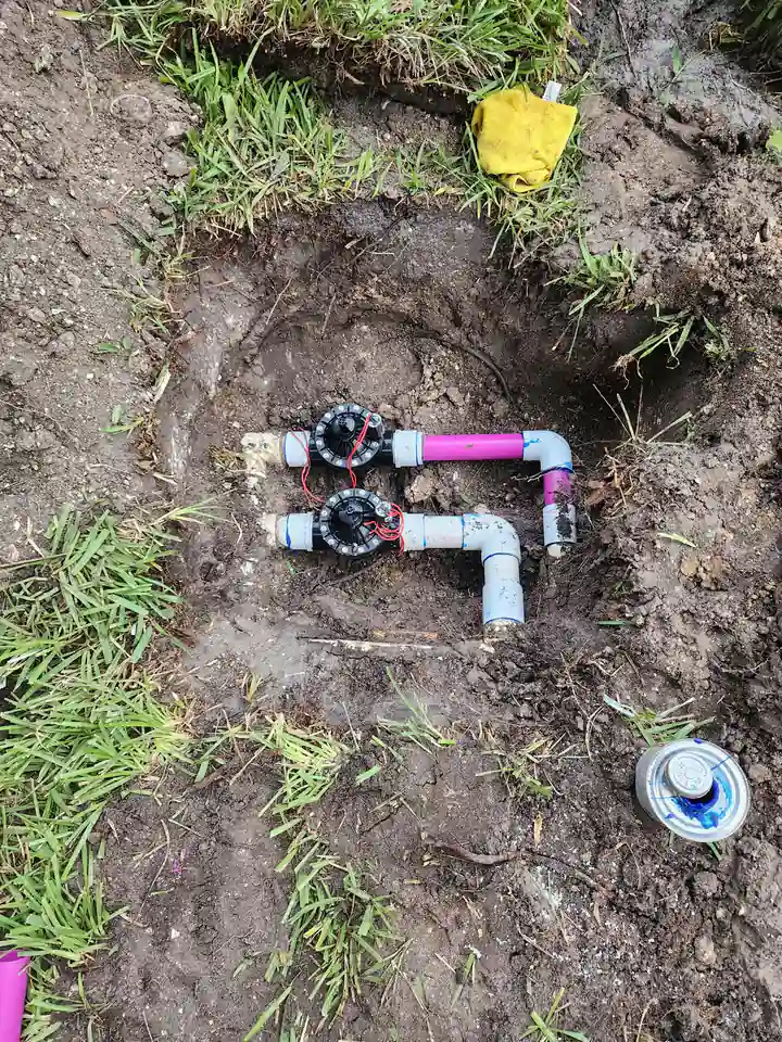 Two new irrigation valves with fittings in an open hole, Sarasota